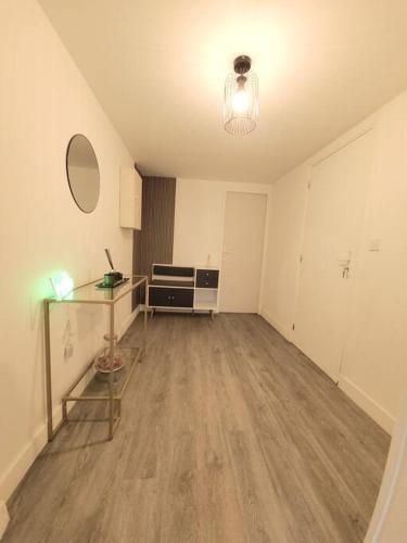 un salon vide avec une table et un bureau dans l'établissement T2 cosy et calme avec terrasse, à Tourcoing