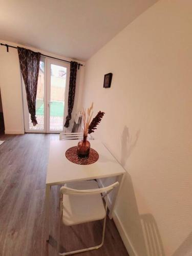 Cette chambre dispose d'une table avec un vase. dans l'établissement T2 cosy et calme avec terrasse, à Tourcoing