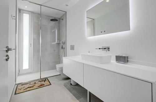 a white bathroom with two sinks and a shower at Villa Izabele - private heated pool with amazing terrace in Callao Salvaje