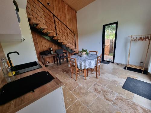 une cuisine avec une table et des chaises dans une pièce dans l'établissement Maisonnette chaleureuse, à Villeneuve-sur-Lot