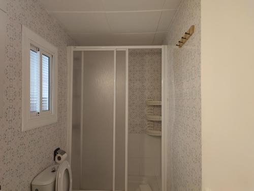 a bathroom with a shower with a toilet and a window at Feel Welcome Barcelona 10 in Cornellà de Llobregat