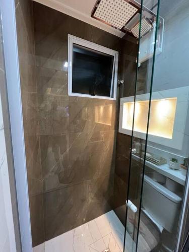 a shower with a glass door in a bathroom at Lindo apartamento em Cuiabá in Cuiabá
