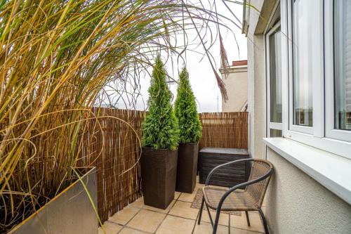 a chair sitting on a balcony with potted plants at Apartament Centrum III in Bydgoszcz