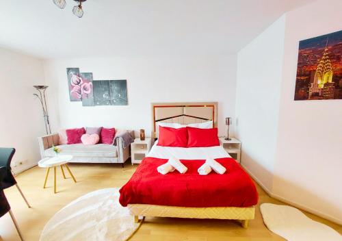 a bedroom with a red and white bed and a couch at L'Art de la Sérénité - Prime Host - Calme & Confort in LʼHay-les-Roses