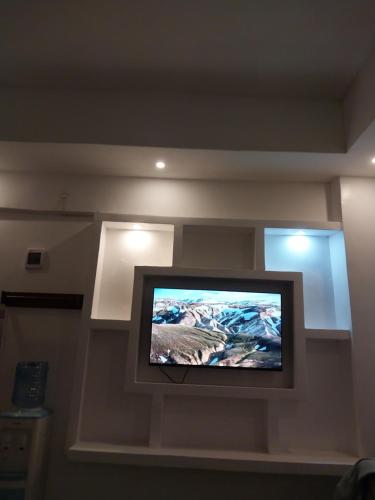 telewizor z płaskim ekranem na ścianie w pokoju w obiekcie Downtown Penthouse w mieście Eldoret