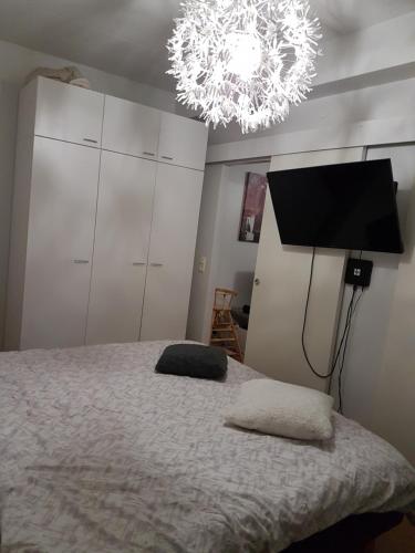 a bedroom with a bed with a television and a chandelier at Top in Oulu