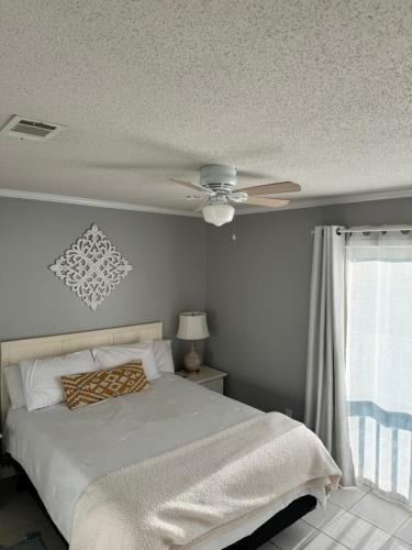 a bedroom with a bed and a ceiling fan at 2-Bedroom Condo on Gulf Shores Beach w/Pool in Gulf Shores