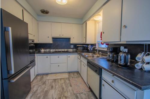 a kitchen with white cabinets and a stainless steel refrigerator at Cozy 2 Bedroom in Cleveland in Cleveland Heights