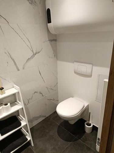 a bathroom with a white toilet in a room at Studio confortable style in Roubaix