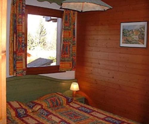 a bedroom with a bed and a window at CHALET LA LICORNE 1 - pied des pistes in Notre-Dame-de-Bellecombe