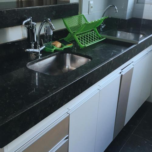 a kitchen counter with a sink and a dish drying rack at Apto Inteiro perto da Cidade do Galo e Wi-Fi Rápido in Vespasiano