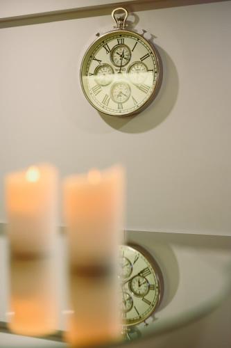 a clock hanging from a ceiling with candles at LOCATION in Sofia