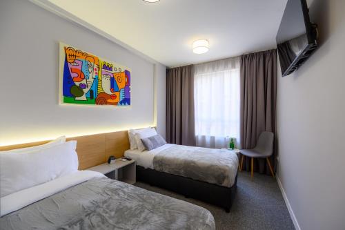 a hotel room with two beds and a window at LOCATION in Sofia