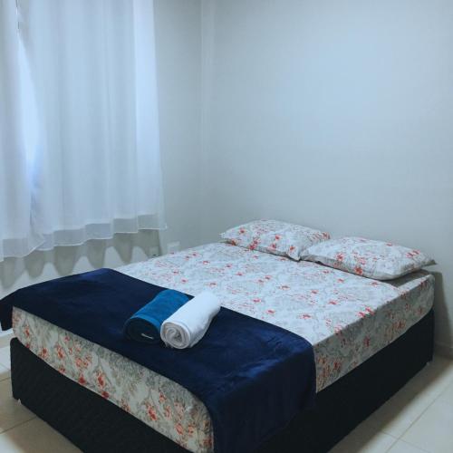 a bed with a towel on top of it at Apto Inteiro perto da Cidade do Galo e Wi-Fi Rápido in Vespasiano