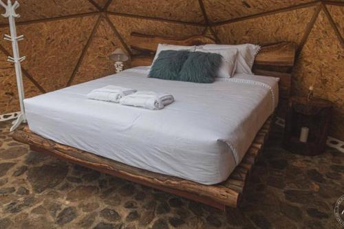 Una cama en una yurta con dos toallas. en Glamping Nuna Experience, en Andahuaylas