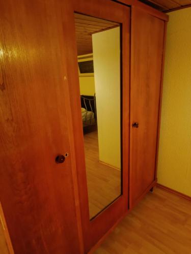 uma porta de madeira com um espelho num quarto em Apartment Untergeschoß, 24 H Check-in,Tv,Internet,Küche, Bad, 2 Guest, freeparking,im Keller, VIP Shuttle Service em Hanôver