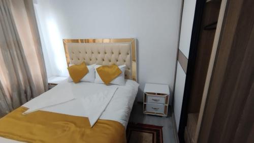 - une petite chambre avec un lit et des oreillers jaunes dans l'établissement Kalya's Goldpark Stays, à Nairobi