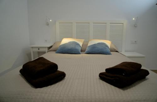 a bedroom with a bed with brown blankets and pillows at VolcanoKite Apartments in Famara