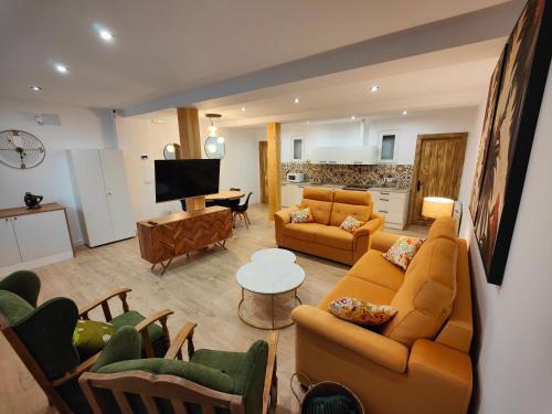 ein Wohnzimmer mit orangefarbenen Sofas und eine Küche in der Unterkunft Apartamentos Santander 2 in Santander
