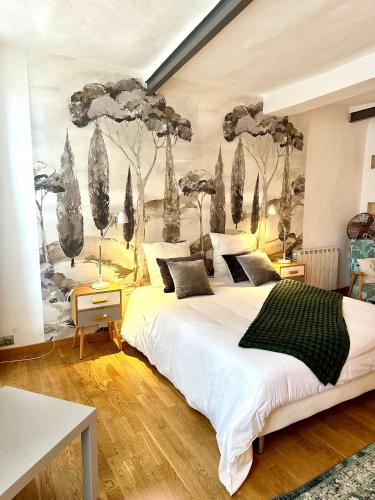 une chambre avec un grand lit avec un tableau au mur dans l'établissement Gîtes Lavande et Jasmin 3 étoiles, à Anduze