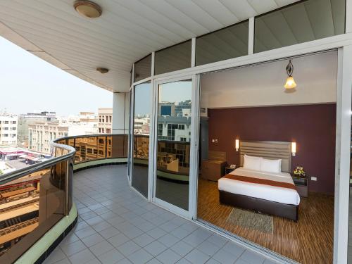 a hotel room with a bed on a balcony at Wave International Hotel in Dubai
