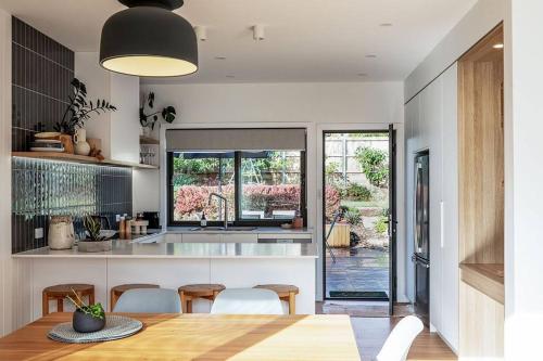 a kitchen and dining room with a table and chairs at Convenient luxury home, minutes to CBD + hospital in Launceston