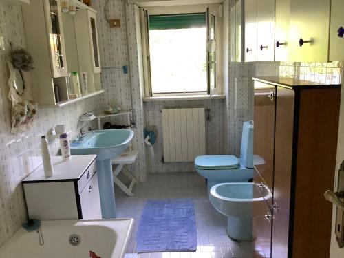 a bathroom with a blue toilet and two sinks at Villa Nanda a 15 minuti da Roma piscina esclusiva , villa nella natura in Formello