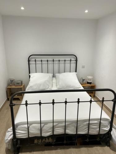 - un lit noir avec des draps et des oreillers blancs dans l'établissement Superbe appartement grande corniche vue sur mer Nice à 4 min du centre ville, à Nice