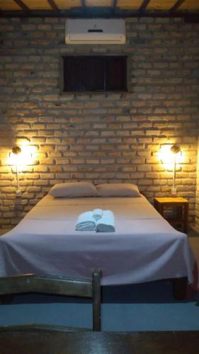 a bedroom with a bed with two towels on it at Jungle House in São Miguel do Gostoso