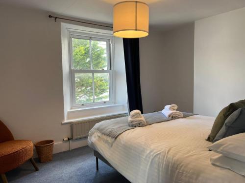 a bedroom with a bed with a window at The Old Bakery, in the heart of St Ann's Chapel in Kingsbridge