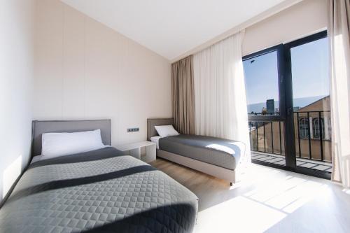 a bedroom with two beds and a large window at Doors Hotel in Tbilisi City