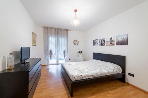 Schlafzimmer mit einem Bett und einer Kommode mit einem TV in der Unterkunft Terrace 27 in Bozen