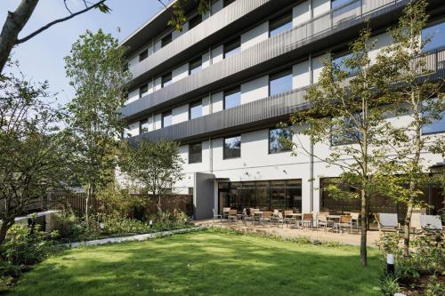an office building with a lawn in front of it at Fairfield by Marriott Kumamoto Aso in Aso