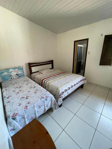 ein Schlafzimmer mit einem Bett und einem Tisch darin in der Unterkunft Casinha da vovó in Tutóia