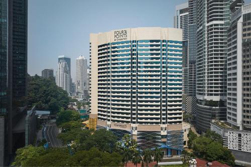 Four Points by Sheraton Kuala Lumpur, City Centre في كوالالمبور: مبنى طويل عليه لافته في مدينه