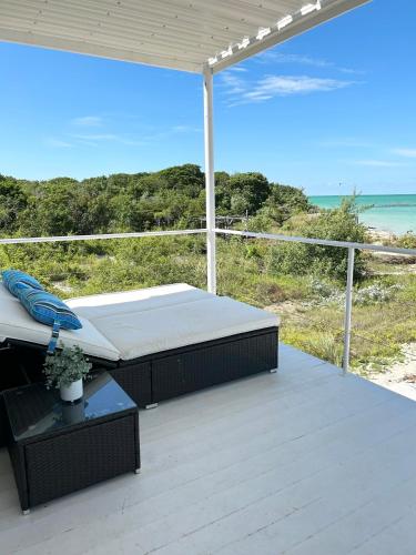 a bed on a deck with a view of the ocean at Villas Secreta Beachfront Resort in San Pedro