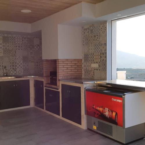 a kitchen with a large window and a counter top at Villa Rural El Mirador in Alora