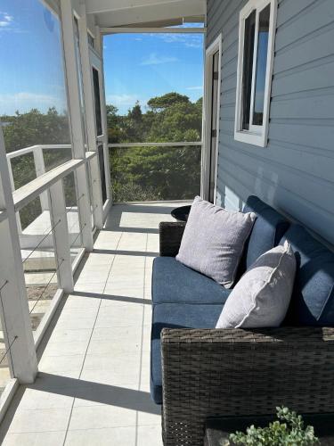 a blue couch sitting on the porch of a house at Villas Secreta Beachfront Resort in San Pedro