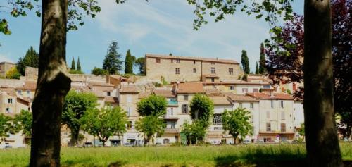 a group of buildings on a hill with trees at Chambre in Jouques