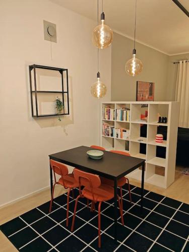 a dining room with a table and chairs and a book shelf at Brooms - Newly renovated central studio apartment in Pietarsaari