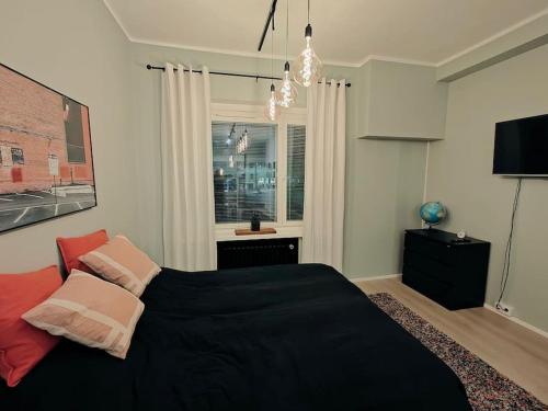 um quarto com uma cama preta e uma janela em Brooms - Newly renovated central studio apartment em Pietarsaari