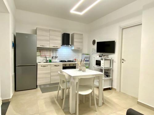 a kitchen with a white table and white appliances at Katy's Holiday House, Private Villa in Terrasini