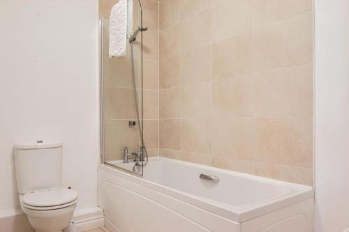 uma casa de banho com uma banheira branca e um WC. em City centre Top floor apartment in Belfast city centre em Belfast