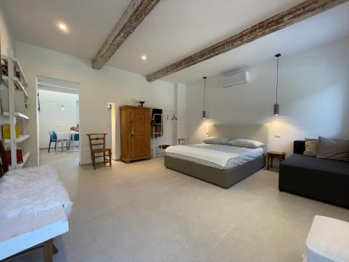 a bedroom with a bed and a couch and a table at Due Di Tutto in Ferrara