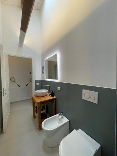 a bathroom with a white toilet and a sink at Due Di Tutto in Ferrara