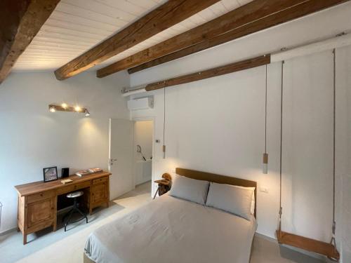 a bedroom with a bed and a wooden desk at Due Di Tutto in Ferrara