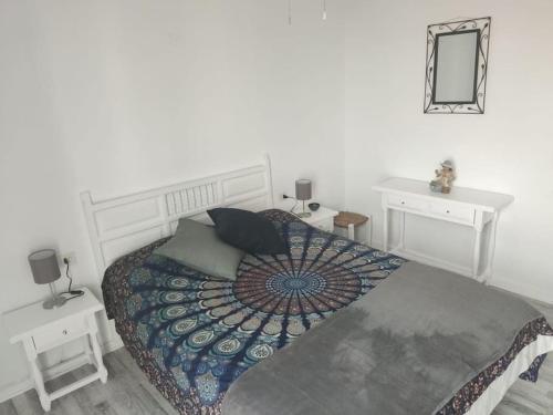 a bedroom with a bed and two tables and a mirror at Apartamento acogedor in El Vendrell