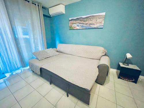 - un petit lit dans une chambre dotée d'un mur bleu dans l'établissement studio city center beach side free paddle beautiful terrace, à Nice