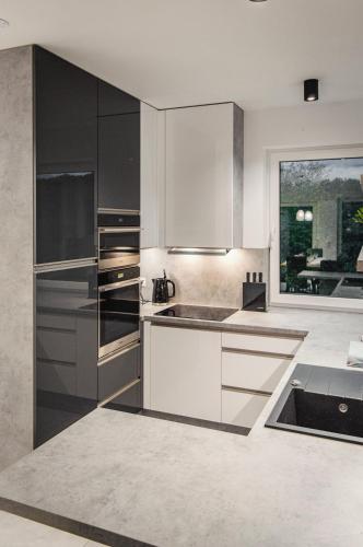 a kitchen with stainless steel appliances and a large window at Domki na wzgórzu in Jarnołtówek