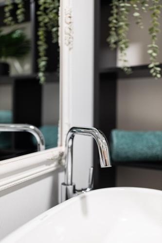 a bathroom sink with a mirror and a white sink at Ultra central apartment in Baia Mare